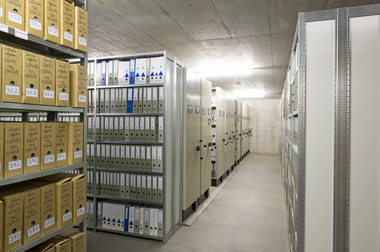 Archiv einer Firma mit Regalen voller Aktenordner.