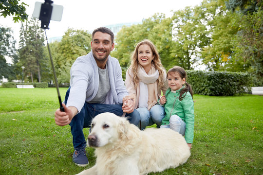 happy family with dog taking selfie by smartphone