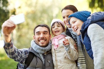 family taking selfie with smartphone outdoors