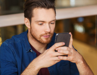 man with smartphone reading message at restaurant