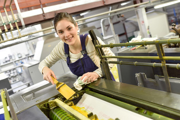 Woman in printshop preparing machine