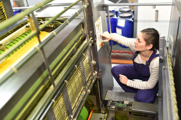 Woman in printshop preparing machine