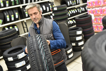 Fototapeta na wymiar Mechanic taking new tire for workshop