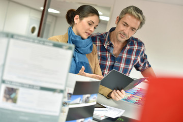 Client in printshop controlling work before final printing