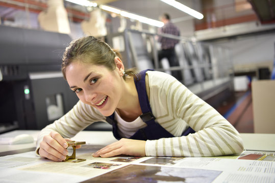 Woman working in print shop, checking document