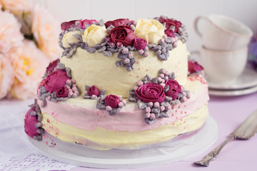 Elegant cake decorated with burgundy cream rose flowers