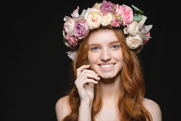 Naklejka premium Smiling redhead woman with wreath from flowers on head