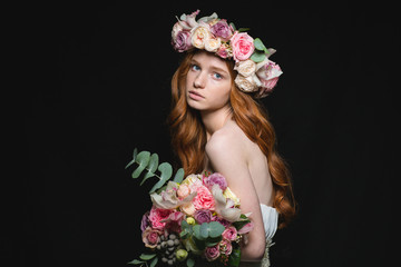 Attrative redhead woman posing with flowers