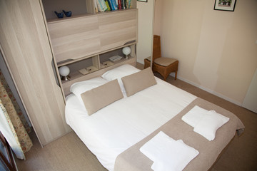Fototapeta na wymiar Double Bed In The Bedroom With Desk Lamp Near It