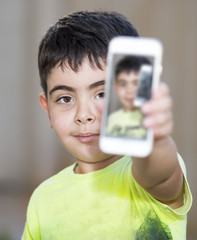 Small boy showing his picture on cellphone screen