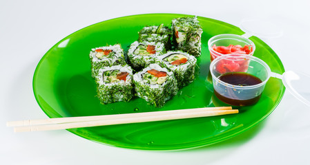 Still meatless vegetable sushi on a green plate with chopsticks,