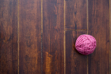 Pink skein over wooden background