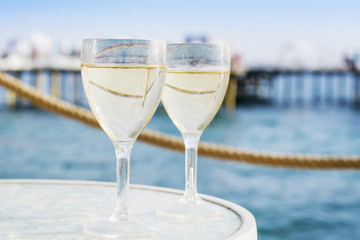 Gin tonic cocktail with lemon slice on a sea background