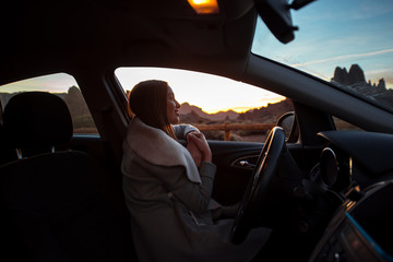 Woman in the car enjoying sunset