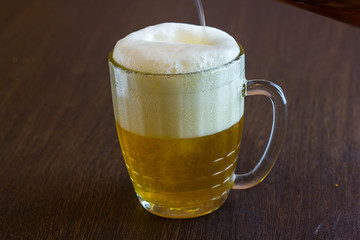 pouring beer from bottle into mug at bar