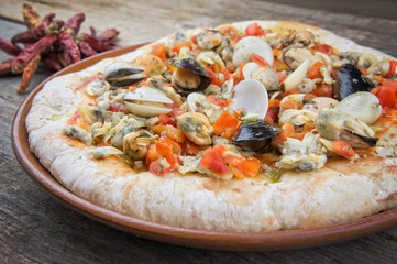 Seafood italian pizza on wooden table