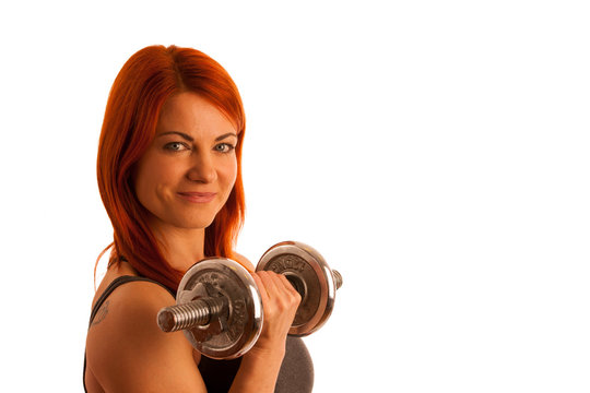 Beautiful young woman working out with dumbels in fitness gym