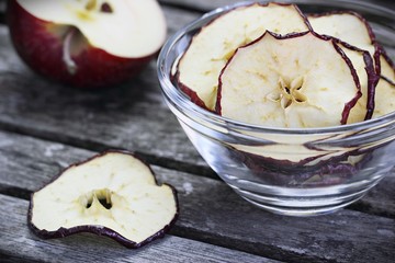 Sun dried apple chips on a rustic wooden table.Healthy snack.Selective focus