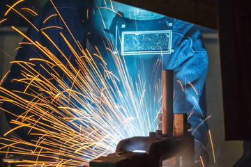 worker with protective mask welding metal