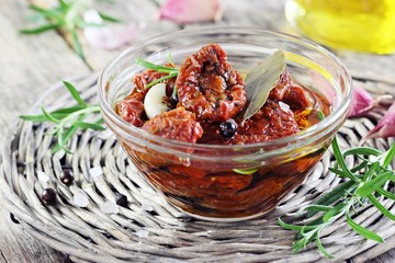 Sun dried tomatoes in olive oil on a rustic wooden table.Selective focus 