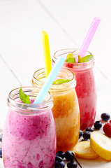 Assorted fruit shakes on white table