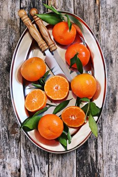 Fresh tangerines with leaves on a rustic wooden table.Selective focus.