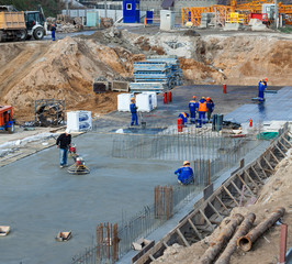 construction site building foundation. Workers polished concrete and waterproofing the surface.