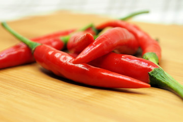 Fresh Red chilli pepper on wood chopping block closeup