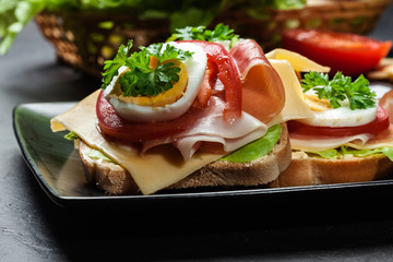 Delicious sandwich with prosciutto ham, cheese, tomato and egg