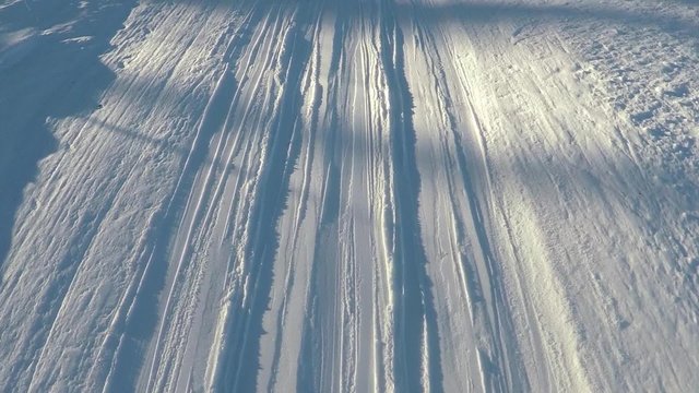 Slow motion ski slope abstract details at sunny day.