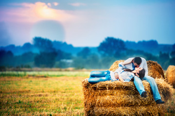 lovers lie on straw and kissing