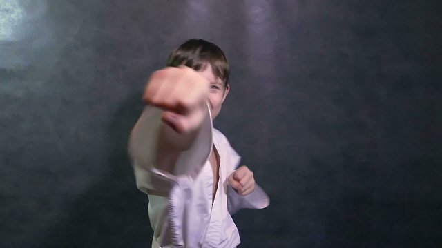 boy teenage in kimono karate fight hands waving fists slow motion