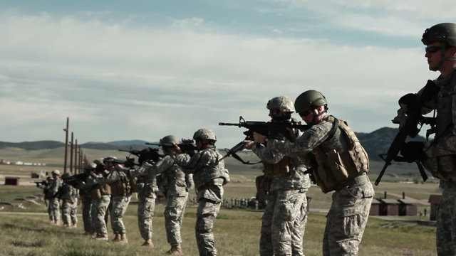 Firing line of soldiers practicing shooting form.