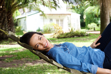 Amiling woman relaxing outside listening to music