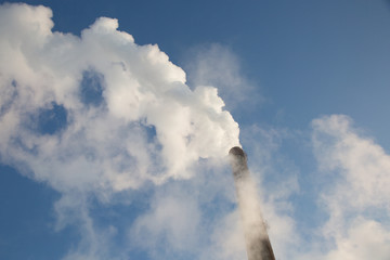 White smoke clouds from a high heating plant chimney