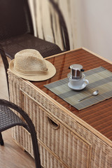 Morning coffee served in vietnam coffee filter on rattan table with two rattan chairs