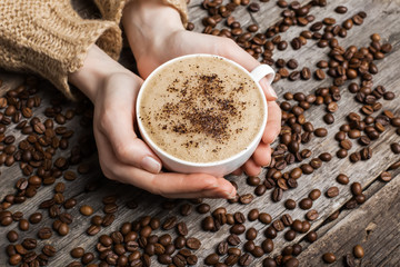 woman holding hot cup of coffee