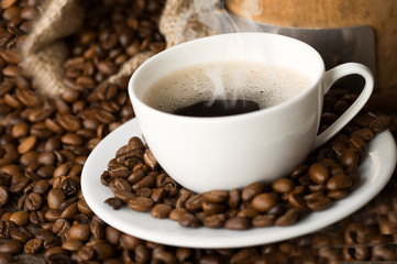 hot coffee and coffee beans on the background of coffee grinders