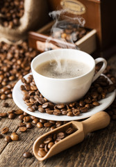 hot coffee and coffee beans on the background of coffee grinders