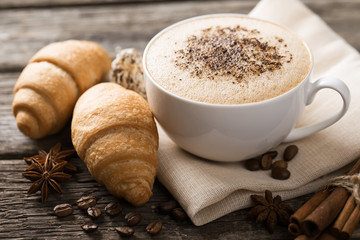 Hot coffee and pastries on a wooden background