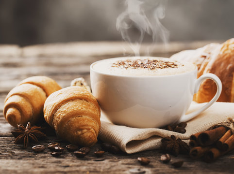 Fototapeta Hot coffee and pastries on a wooden background