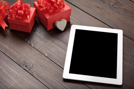 White tablet computer with red gift box