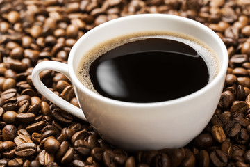 cup of hot coffee on coffee beans background