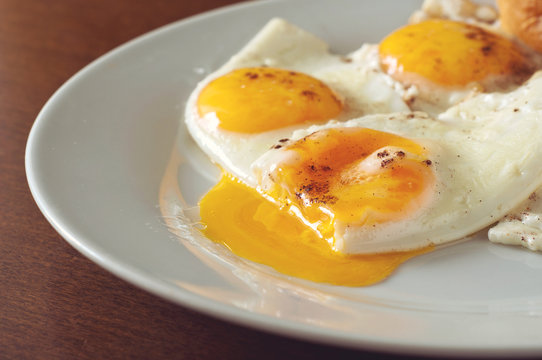 fried eggs closeup on a white plate