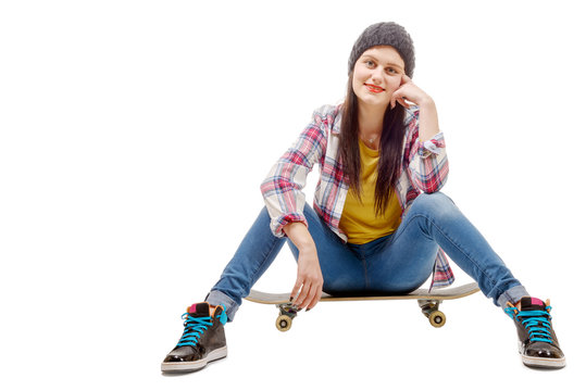 Beautiful young woman posing with a skateboard, seat on skate