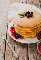 delicious pancakes on wooden table with fruits