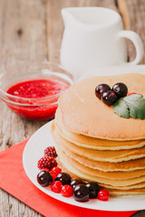 delicious pancakes on wooden table with fruits