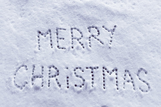 Written words Merry Christmas on a snow field, new year concept, filter applied