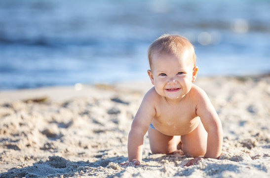 Cute baby boy crawling on beach