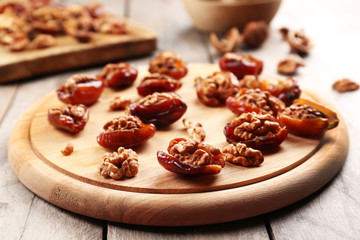 Walnut, date fruit on wooden table, close-up